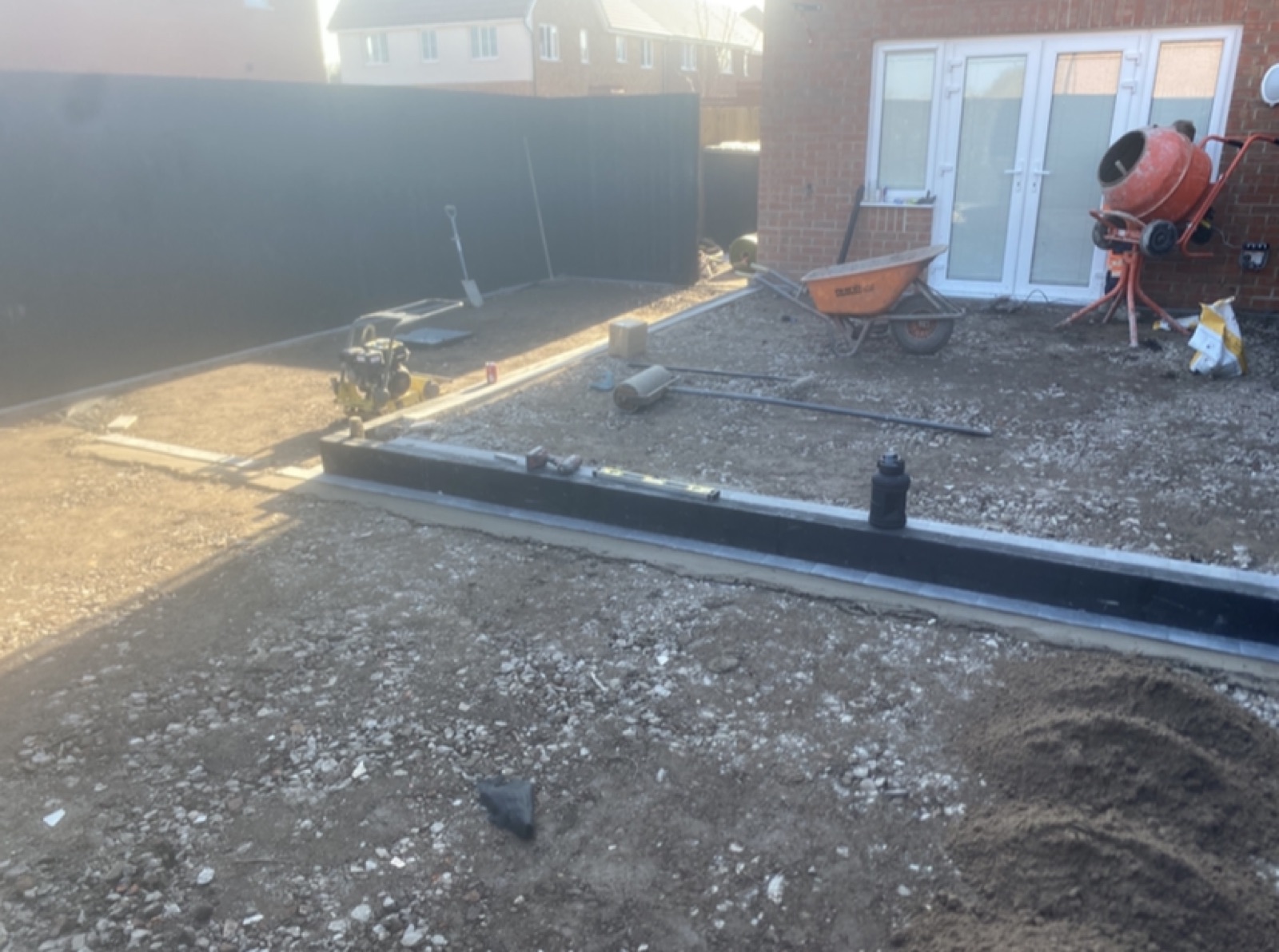 Garden mid-job with cement mixer and wheelbarrow